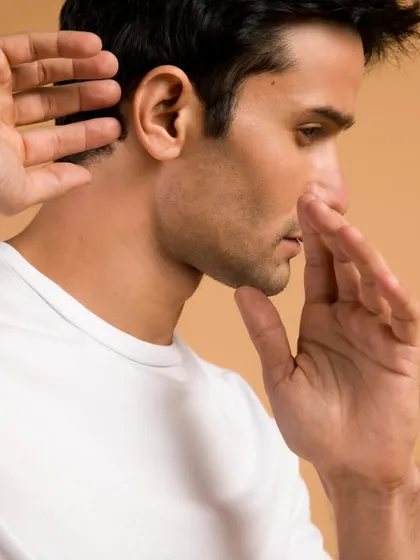 A close-up portrait for Crossbeats that captures a sense of deep listening. The model's posture and the clean, warm background create a feeling of focus and immersion, subtly communicating the quality of the audio product.