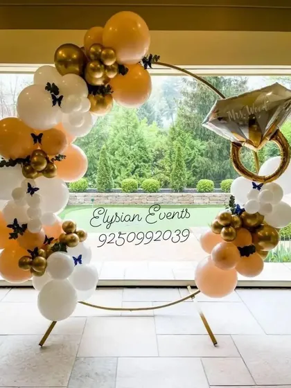 This is my popular ring ceremony backdrop, perfect for engagement parties. The design features a large golden ring frame decorated with an organic balloon garland in white and gold, accented with a large diamond ring foil balloon to celebrate the occasion.