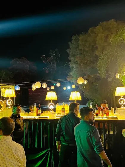 Guests enjoying drinks at our well-lit outdoor bar. We ensure the bar area is both functional and aesthetically pleasing.