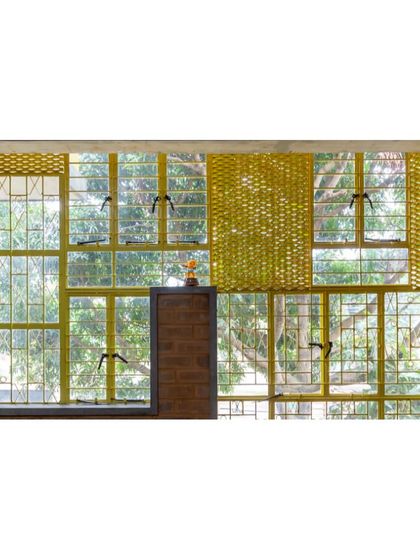 Inside the Mathru Centre, the collage of reclaimed windows frames views of the large mango trees outside. This not only brings nature into the classroom but also fills the space with diffused, natural light.