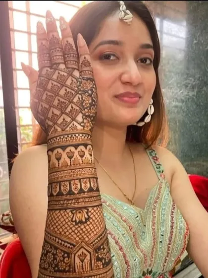 A happy client posing with her full-arm mehndi design.