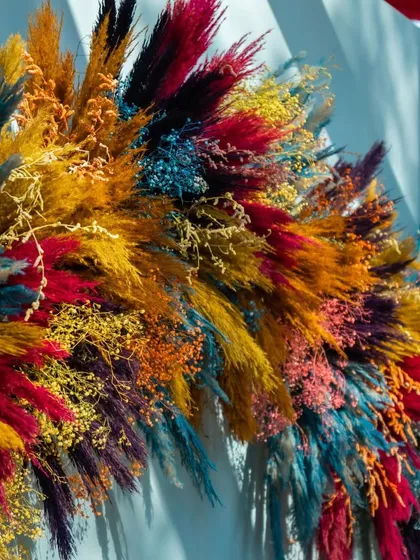 A detailed shot of the multi-colored floral arrangement used for the photo booth, featuring a rich texture of dried and dyed pampas grass.