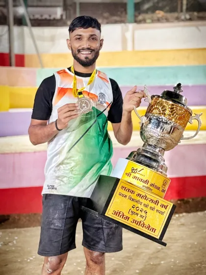 An athlete proudly posing with his medal and the runner-up trophy. Patience and persistence pay off.