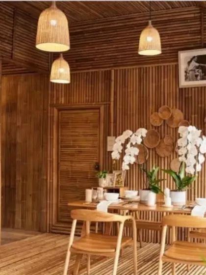 A dining room fully paneled with bamboo, creating an immersive, natural environment. Our simple, bell-shaped pendant lights hang above the table, their warm glow enhancing the rich tones of the bamboo walls and floor.