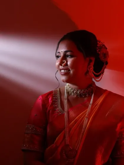 An artistic shot using dramatic lighting to highlight the bride's features and her stunning traditional look.