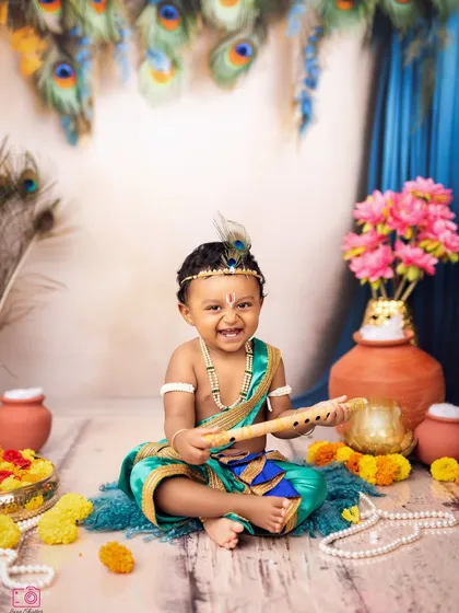 A joyful little Kanha with his flute. The vibrant colors of the costume, peacock feathers, and flowers create a visually stunning portrait.