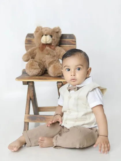 A classic portrait of a little boy with his teddy bear. The clean white background makes this a timeless photo.