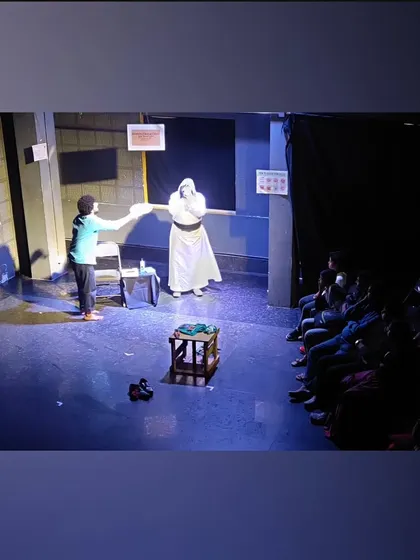 A scene from a student play where actors use masks and dramatic lighting to create a mysterious and compelling visual.