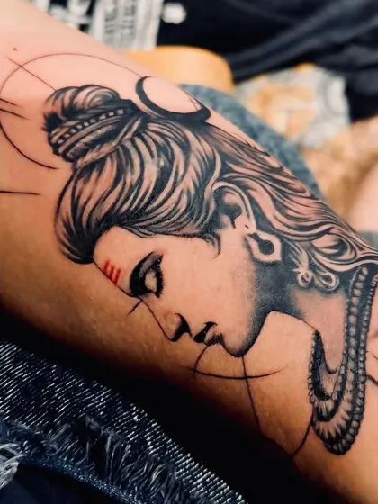 This detailed Lord Shiva tattoo on the forearm captures a serene yet powerful expression. I focused on fine line work for the hair and smooth shading on the face, with geometric accents to create a modern take on a classic spiritual design.