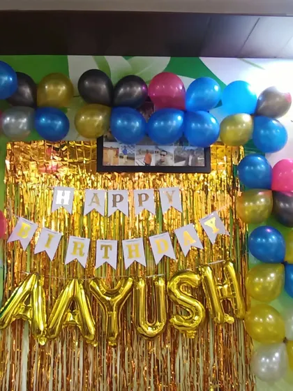 A simple birthday backdrop with a gold shimmer curtain and a colorful balloon frame. This is an easy and effective way to create a photo corner at home.
