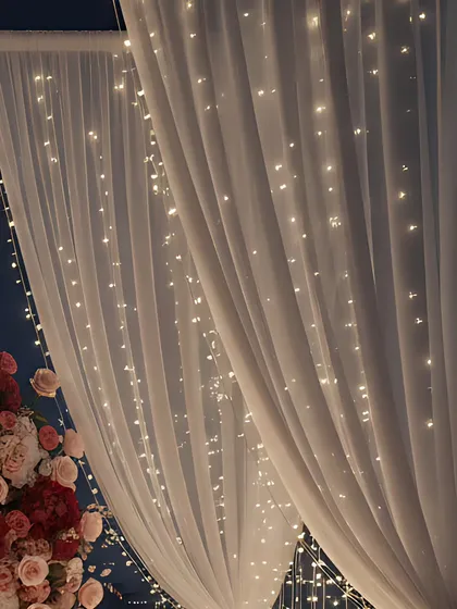 A similar view of the fairy light and drape combination, emphasizing the warm, inviting glow they produce. This lighting is versatile and can be used to enhance entrances, stages, or entire venue walls.