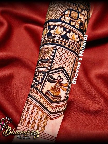 A close-up of a beautifully detailed arm design, featuring an auspicious kalash motif and intricate floral patterns.