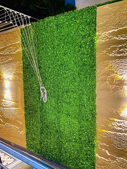 This section of the compound wall features a simple, dense green panel. It's a practical solution for covering plain walls and is even designed to accommodate functional items like this clothesline.