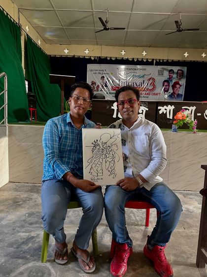 A student from my workshop at Gogamukh College, Dhemaji, holding his completed Radha-Krishna signature art.