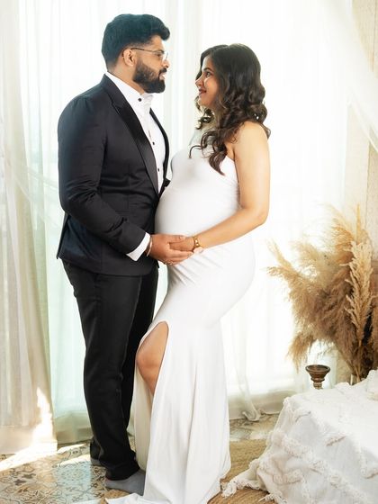 A classic couple's portrait, both dressed elegantly. The way they look at each other speaks of their shared excitement for the journey ahead, captured in a beautifully lit studio.