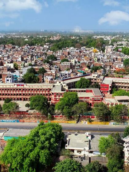 A clear daytime drone view of the St. Anthony's Convent School building in Prayagraj, surrounded by greenery.
