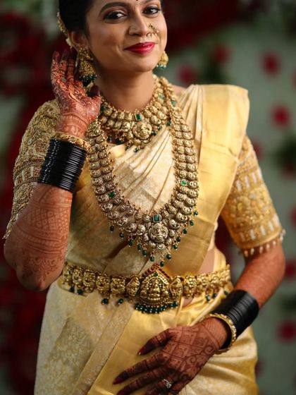 This happy client looks gorgeous in a traditional antique jewellery set with green stone accents. The layered necklaces and matching hip belt create a complete, authentic bridal look.