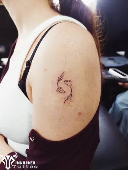 A delicate Pisces symbol, representing the duality of the zodiac sign. This fine-line tattoo is a perfect example of how a small design can have significant personal meaning.