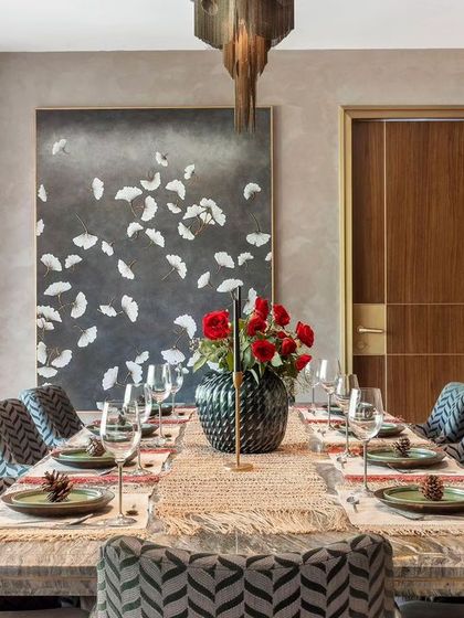 The formal dining room, designed for elegant dinner parties. The space features patterned chairs, a solid wood table, and dramatic artwork, all under a textured ceiling that adds architectural interest.