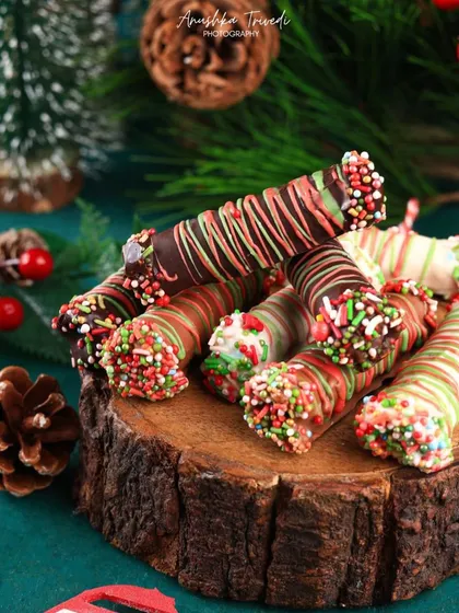 A tight close-up on the Christmas chocolate rolls, focusing on the texture of the sprinkles and chocolate drizzle. This makes them look extra crunchy and delicious.