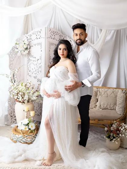 A glamorous mom-to-be celebrating her journey. I provide a collection of beautiful maternity gowns, like this elegant white dress, to make you feel absolutely radiant. This portrait was taken in my studio against a soft, dreamy backdrop.