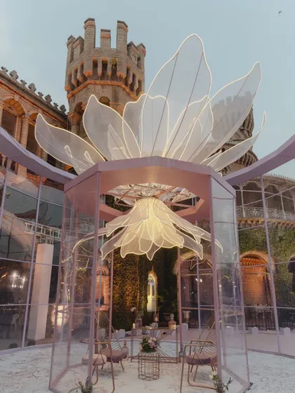 We create experiences, not just seating areas. For this reception at a majestic castle, we designed and built 28-foot tall transparent acrylic lounges with massive fabricated flowers lit from within, offering guests a magical space to immerse themselves in.