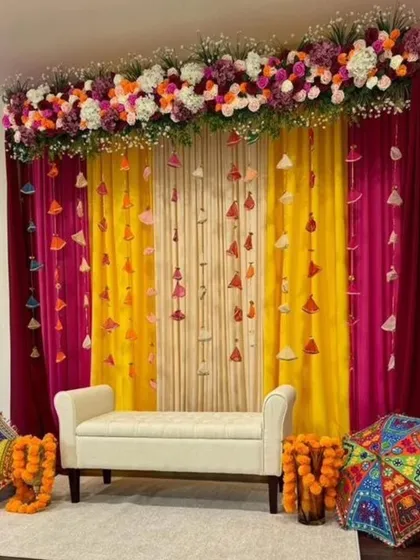This decor brings the colors of Rajasthan indoors, with bright drapes, playful tassels, and decorative umbrellas creating a festive mehendi corner.