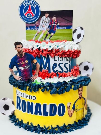 A two-tier cake celebrating football legends Messi and Ronaldo.