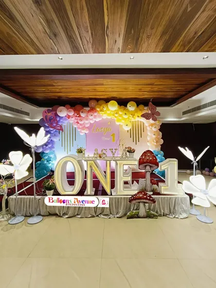 A full stage view of the rainbow butterfly first birthday party, capturing the entire vibrant and cheerful setup.