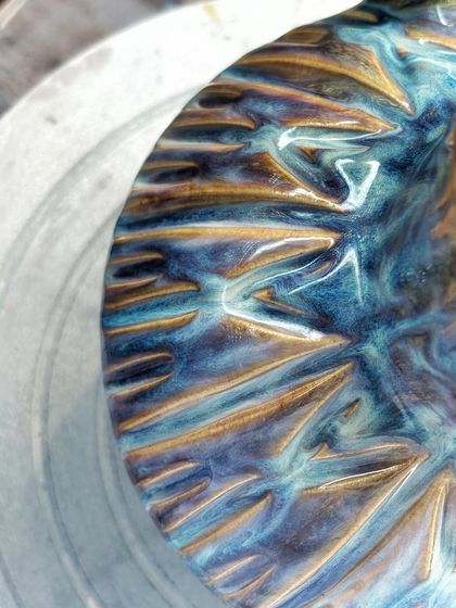 A close-up of the incredible glaze on my new pitcher. Look at the way the colors melt and flow into each other, creating a surface that feels alive. This is the unpredictable magic that happens inside the kiln.