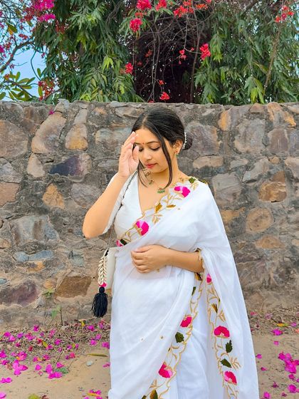 A candid moment in the white mul cotton saree. The messy bun with a gajra adds a traditional South Indian touch to the look.