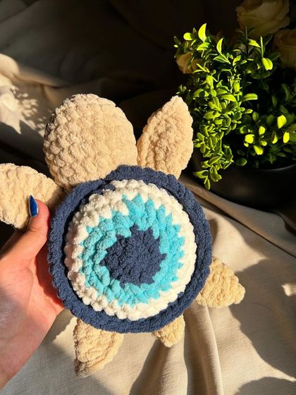A top-down view of our evil eye turtle. This design combines a traditional symbol of protection with a cute and cuddly toy.