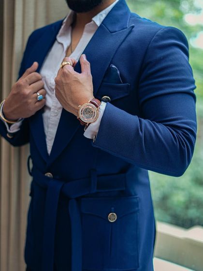 A close-up shot of a client's impeccably tailored blue suit, highlighting the fit and the confident way he wears it.