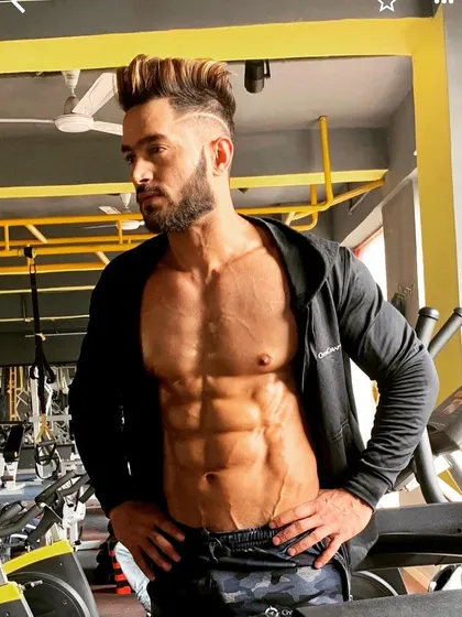A dream does not become reality through magic. It takes hard work. This pose highlights a deeply etched six-pack, the result of a strict diet and core training regimen.