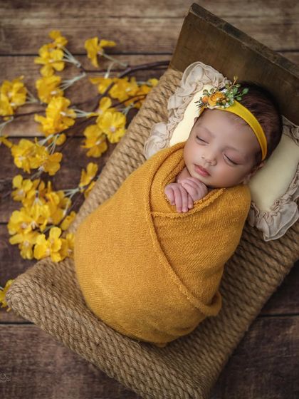 Another perspective of the rustic newborn session, with the baby lying on a jute bed, showing the textures of the wood and fabric.