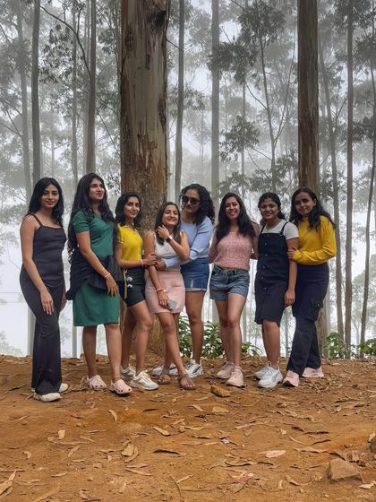 Posing for a group photo amidst the tall, mist-covered trees of the pine forest.