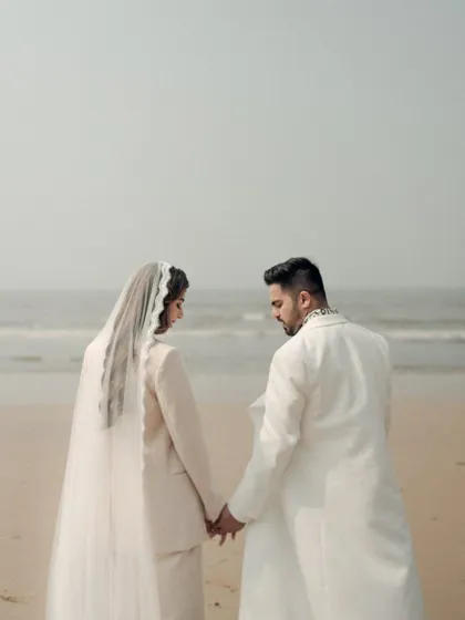 A quiet moment of reflection by the sea. This portrait captures the couple holding hands, looking out at the horizon, a beautiful metaphor for the journey they are beginning together.