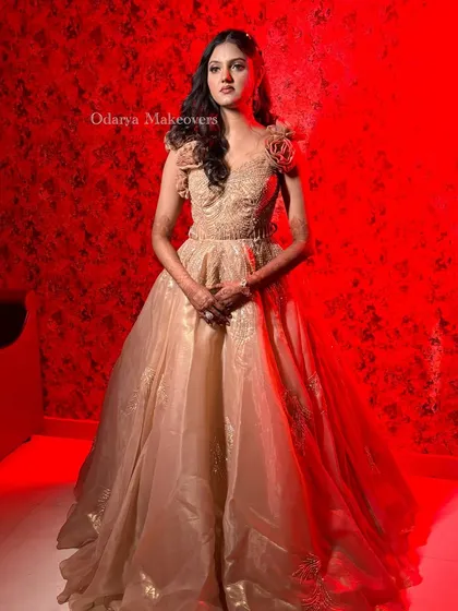 A dramatic portrait from a reception photoshoot. The red lighting highlights the beautiful structure of her gown and the flawless finish of her makeup.