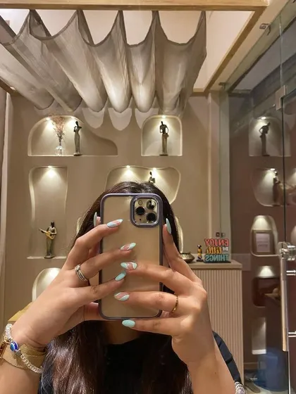 Your nails are the perfect accessory. This mirror selfie shows off a fresh set of mint green nails with delicate art, proving our studio is the perfect place to get that Instagram-worthy shot.