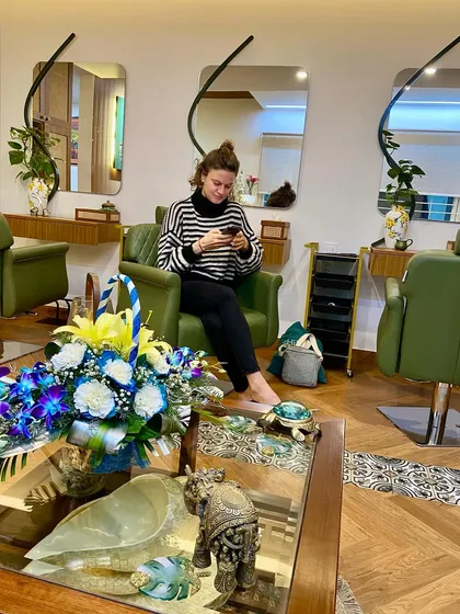 A candid moment of a client enjoying the peaceful atmosphere of the salon before her treatment begins.