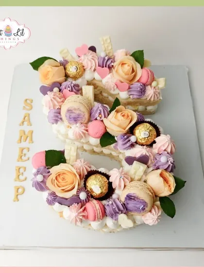A beautiful "S" monogram cake for Sameep, loaded with macarons, Ferrero Rocher chocolates, and fresh flowers in pastel shades.
