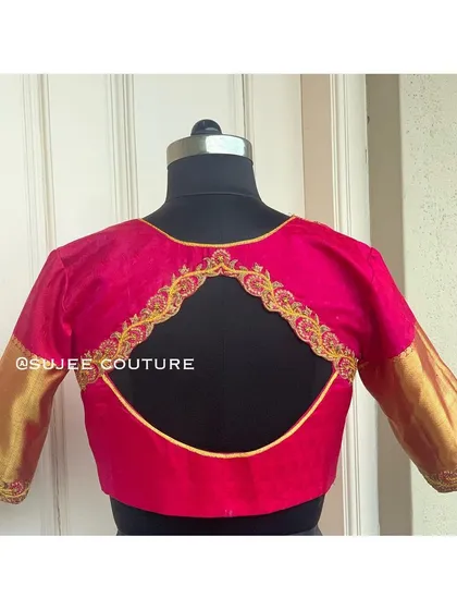A simple and elegant pink blouse with a large circular back cutout. The cutout is framed with delicate gold embroidery, and the sleeves are a contrasting gold brocade.