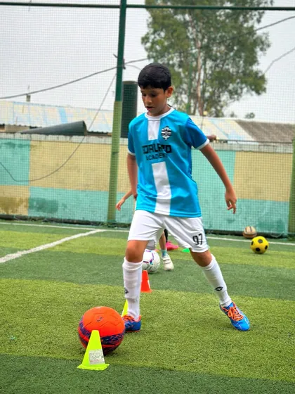 Ball control is key. Here, a player practices his close-control dribbling skills around cones, a fundamental drill in our training sessions.