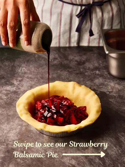 The first step in making our Strawberry Balsamic Pie: filling the buttery crust with roasted strawberries and balsamic glaze.