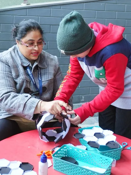 Our parties can include creative activities too. Here, a guest is making a paper football during the craft session.