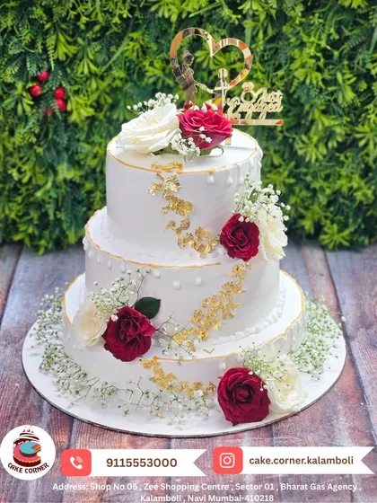 This is a classic three-tier anniversary cake, decorated with fresh red and white roses and a touch of gold leaf. It’s simple, beautiful, and perfect for celebrating your love story, whether it's for a wedding or an anniversary.