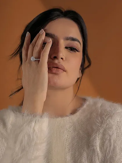 A moment of quiet confidence. A woman wears a stunning marquise-cut diamond halo ring, a piece that reflects her unique style and individuality. I create jewellery that becomes a part of you.