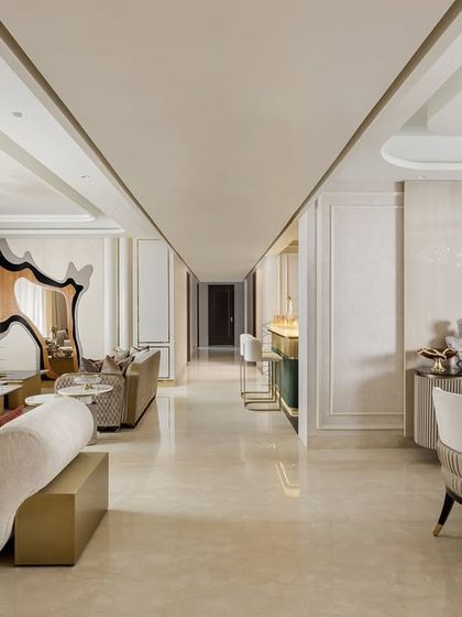 An expansive view showing the seamless flow from the living area to the dining space and bar. We designed the layout to be open and interconnected, perfect for a family that loves to host. The consistent marble flooring and neutral palette create a cohesive and harmonious feel.