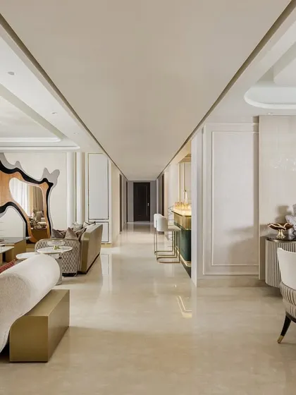 This expansive living and dining area is designed with our signature touch of understated gold accents. The open layout connects multiple zones for lounging and dining, unified by creamy marble floors and bespoke chandeliers that define each space.