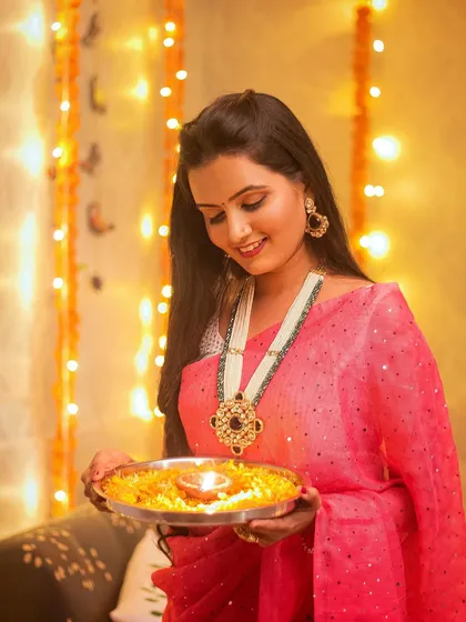 Another beautiful shot with the puja thali. The focus on the diya adds a sense of tradition and devotion.